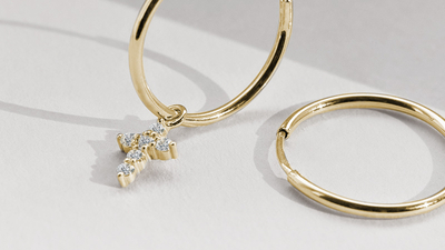 Hoop earrings made of yellow gold with a diamond cross pendant