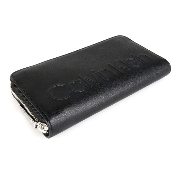 Je uzavíratelná na zip. Přední stranu zdobí embosované logo značky. CALVIN KLEIN, JE UZAVÍRATELNÁ NA ZIP. PŘEDNÍ STRANU ZDOBÍ EMBOSOVANÉ LOGO ZNAČKY. - DÁMSKÉ PENĚŽENKY - PENĚŽENKY