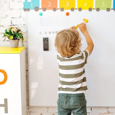 montessori detská izba - dieťa píše na tabuľu
