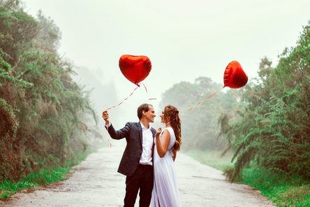 zamilovaná dvojica s červenými balónmi v tvare srdca 