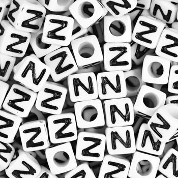 White plastic bead 7 mm with letter N