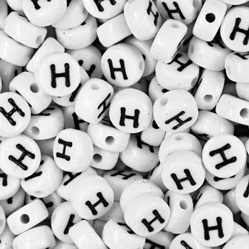 White plastic bead 7x4 mm with letter H