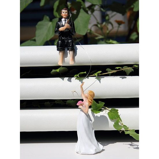 Groom with rod catches the bride 50% action - wedding cake figurines
