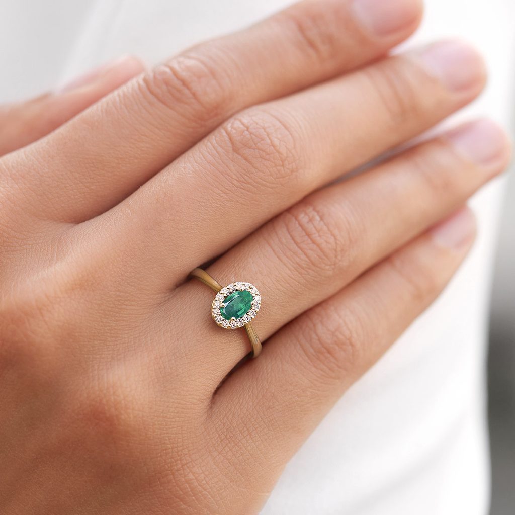 Emerald and diamond halo ring in yellow gold | KLENOTA