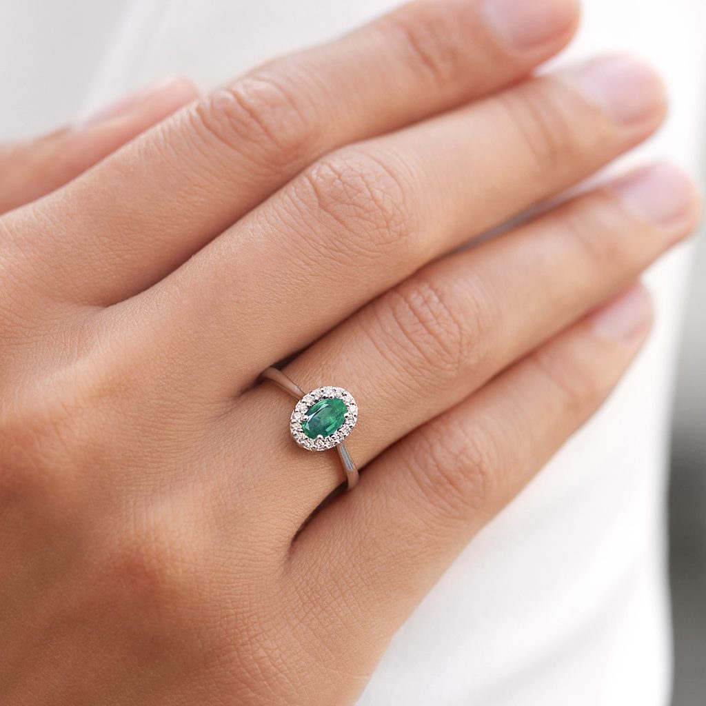 Emerald and diamond halo ring in white gold | KLENOTA