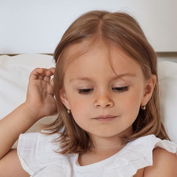 Les premières boucles d'oreilles d'une petite fille