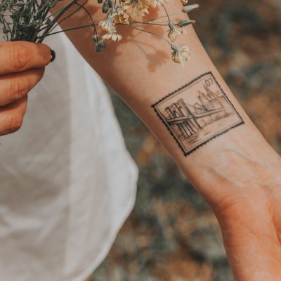 tetovanie na predlaktí v štýle poštovná známka s mestom
