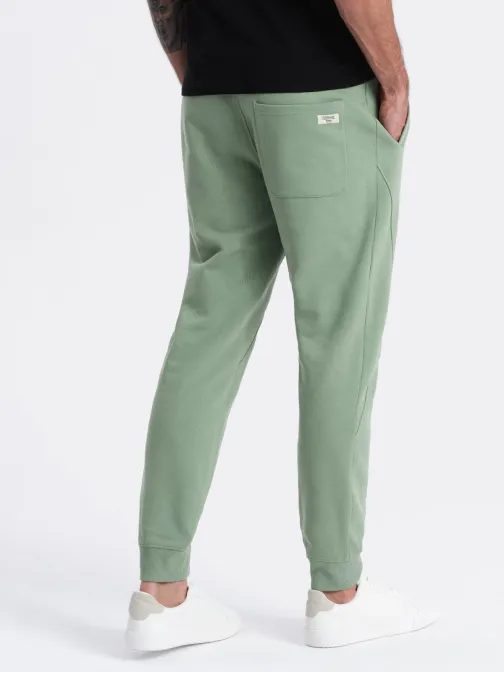 Zelené tepláky s trendy prešívaním V3 PABS-0173