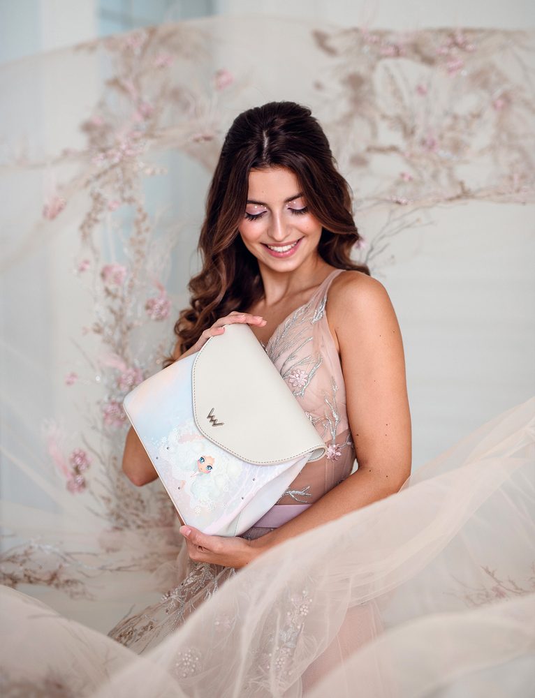 VUCH Magical Anastasia.

Kombinácia potlače, výšivky, kovových prvkov a výrazného prešívania
Magicky snová veľkooká bábika a listy tancujúce vo vetre
Podpis „VUCH BY Dušinka✤“ na zadnej strane kabelky
Dve oddelené vrecká na zips prekryté klopou
 Vušinky
Priprav sa na magickú jazdu do sveta fantázie, kde každý krok znamená nový príbeh a každý moment má nádych kúzla.