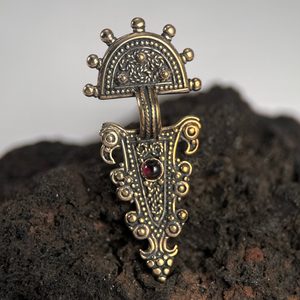 Têtes d'aigle, Faibule du haut Moyen Âge refaite comme un pendentif, bronze