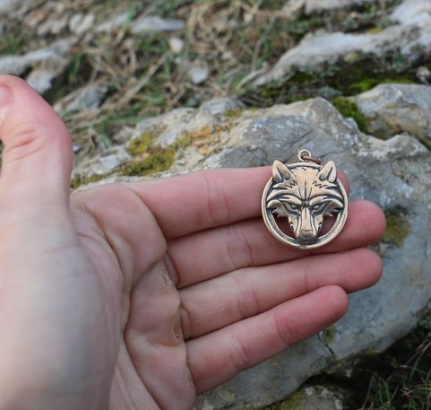 WOLF'S HEAD IN A RING, BRONZE PENDANT