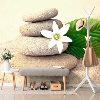 FOTOTAPETE WEISSE BLUME UND STEINE IM SAND - TAPETEN MIT FENG SHUI-MOTIVEN - TAPETEN