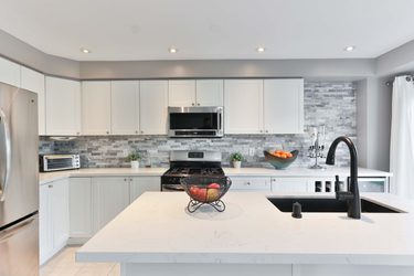 biela kuchyňa s tehlovým obkladom sivej farby