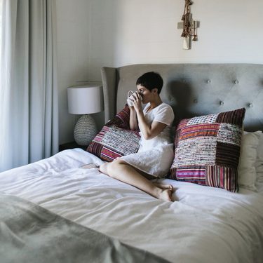 spálňa, žena v posteli pije kávu