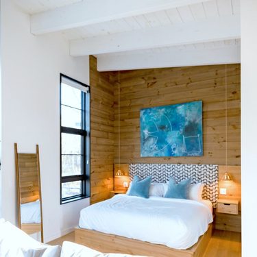 spálňa s dreveným obkladom, modrým obrazom 