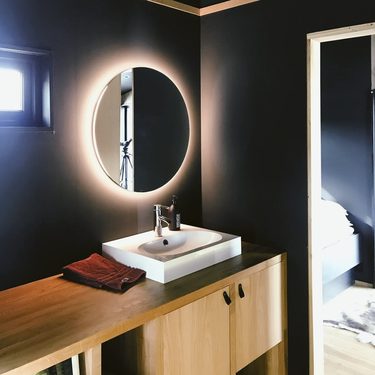 moderná kúpeľňa s okrúhlym zrkadlom na stene