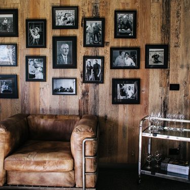 vintage obývačka, staré čiernobiele fotografie zavesené na drevenej stene 