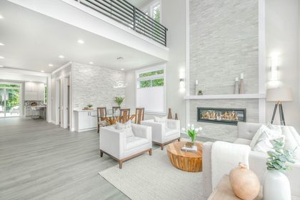 biela moderná obývačka so sivou akcentujúcou farbou, krb a tehlový obklad