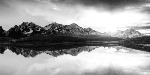 WANDBILD SCHILLERNDER SONNENUNTERGANG ÜBER DEM BERGSEE IN SCHWARZ-WEISS - SCHWARZ-WEISSE BILDER - BILDER