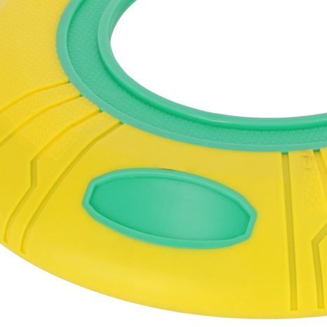 DETAILNÍ POHLED NA AERODYNAMICKÉ ZAOBLENÍ ZÁŘIVĚ ŽLUTÉHO PSÍHO FRISBEE DISKU