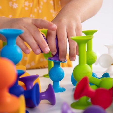 RŮZNÉ TVARY A BARVY DÍLKŮ SQUIGZ ROZLOŽENÉ PRO KREATIVNÍ HRU