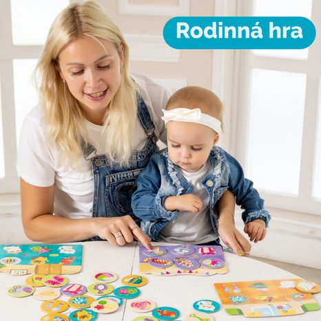 RODIČE S DĚTMI SI HRAJÍ BAREVNÉ OBRÁZKOVÉ LOTTO FAR FAR LAND U STOLU