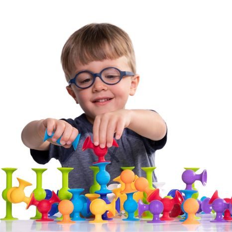 DÍTĚ STAVĚJÍCÍ BAREVNOU KONSTRUKCI Z PŘÍSAVEK SQUIGZ
