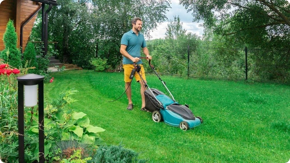 Sekání trávníku na malé zahradě pomocí elektrické sekačky