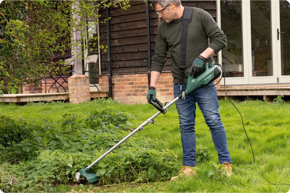 Elektrický křovinořez při sečení hustého a přerostlého porostu