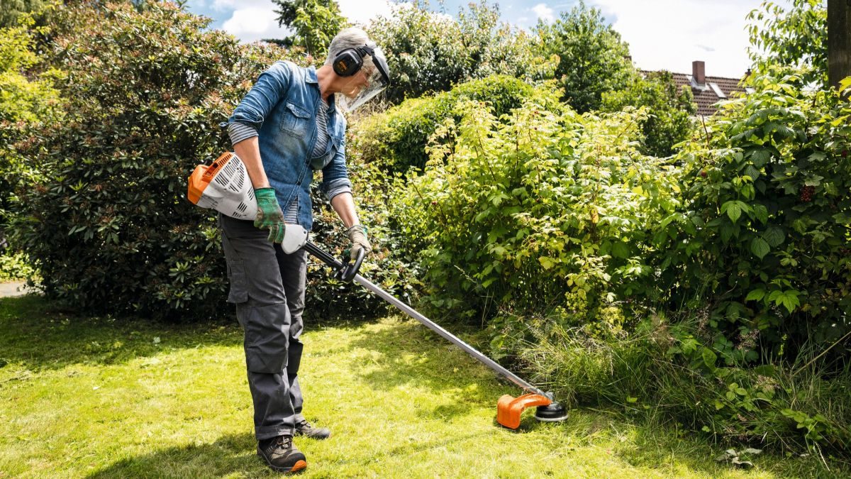 Křovinořez se strunou při dosekávání porostu v zahradě