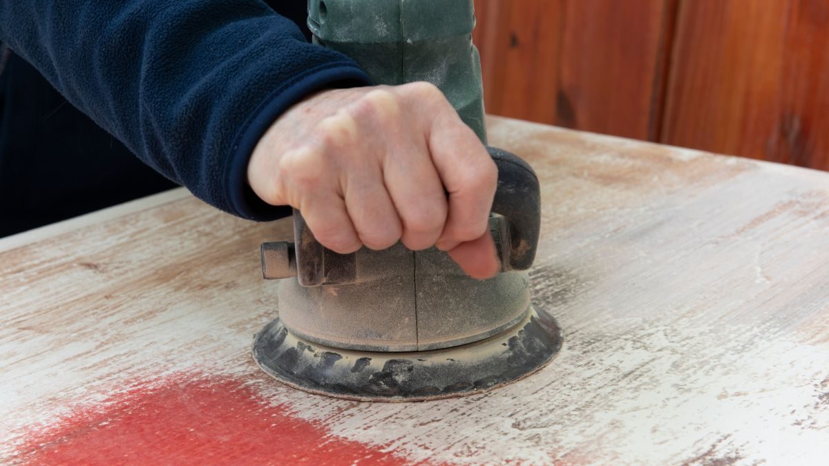 Broušení starého nátěru excentrickou bruskou při renovaci dřeva