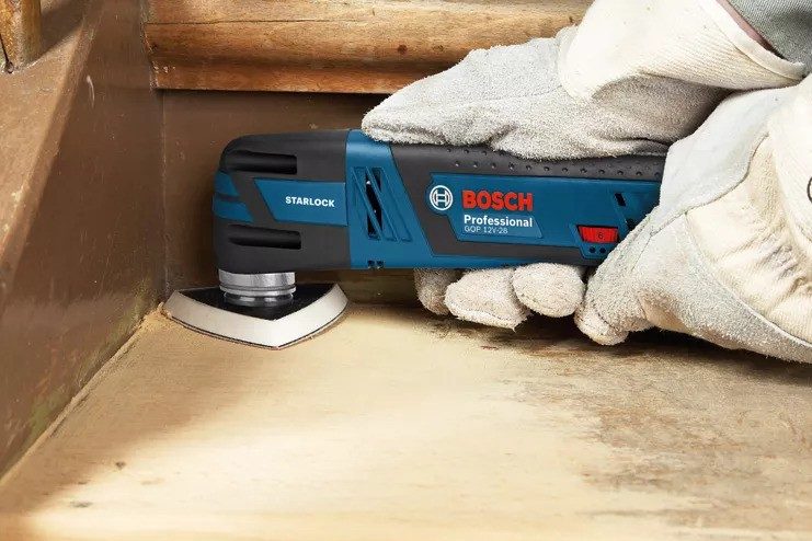 Oscilační bruska při broušení v rohu dřevěného schodu