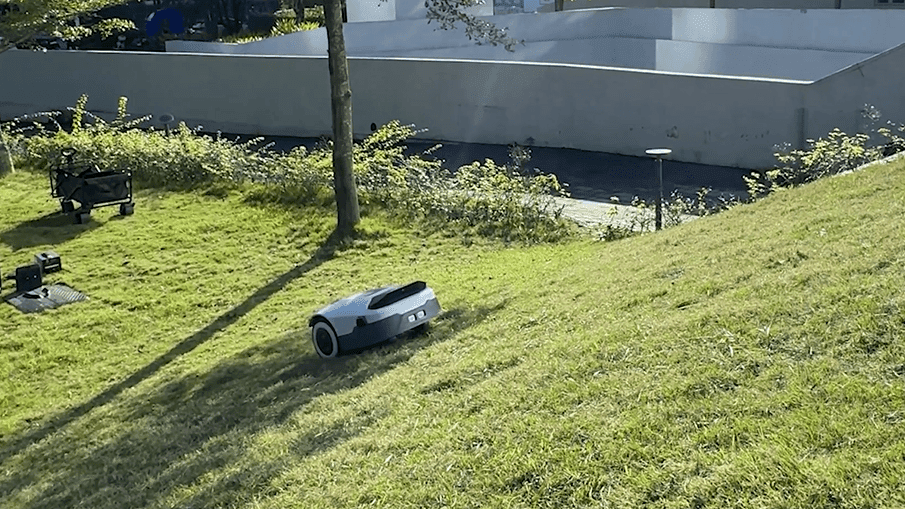 Robotická sekačka při práci na svažité zahradě