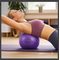 Žena cvičí pilates s veľkým fialovým overballom Sportago 30 cm pod chrbátom na fialovej podložke.