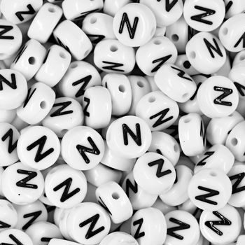 White plastic bead 7x4 mm with letter N