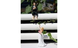 Ženich s prutem chytá nevěstu 50% akce - svatební figurky na dort