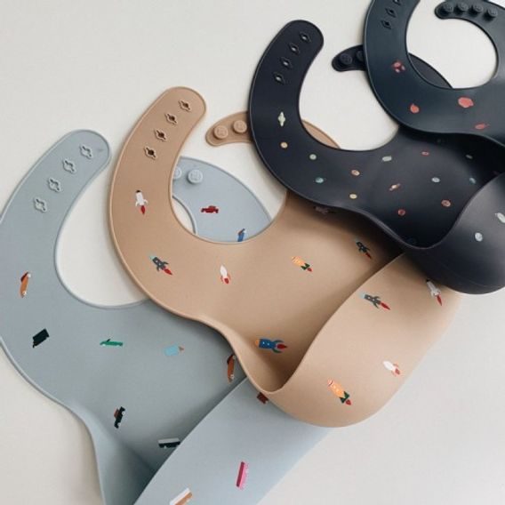 Mushie Silikonový bryndák DINOSAURS