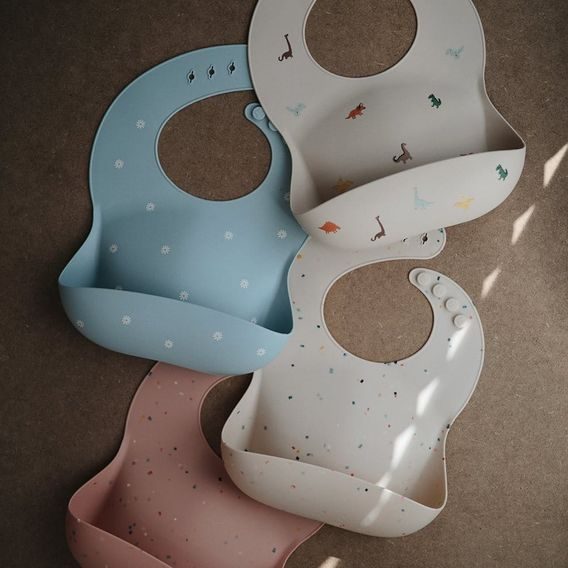 Mushie Silikonový bryndák DINOSAURS