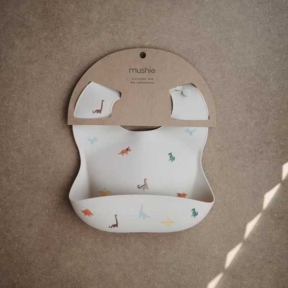 Mushie Silikonový bryndák DINOSAURS