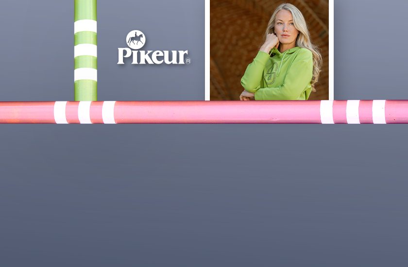 Dívka opřená o překážku, oblečená v zelené mikině z nové jarní kolekce Pikeur 2026.