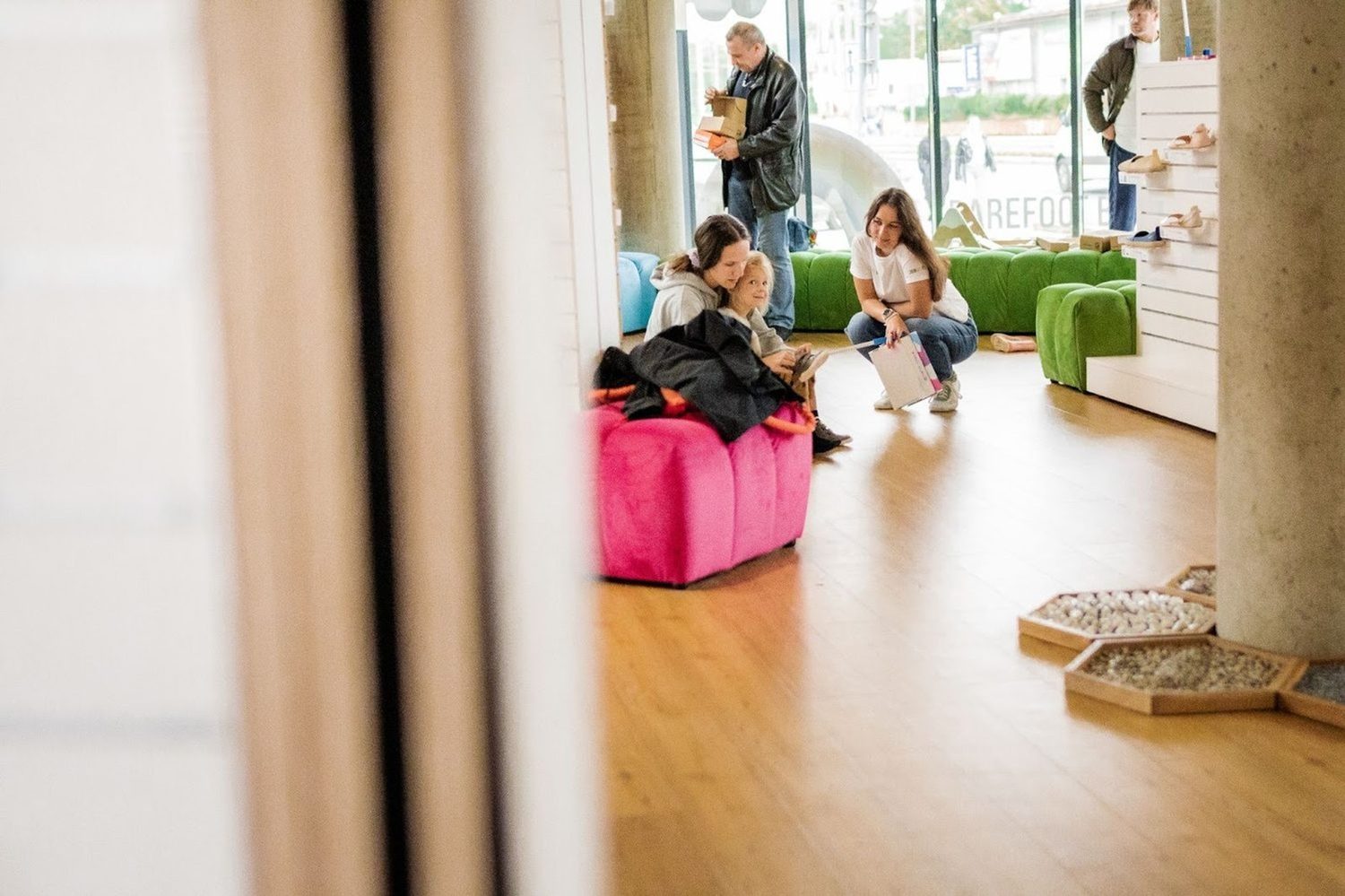 Prodavačka naBOSo pomáhá s výběrem barefoot bot mamince s dítětem v pražské prodejně