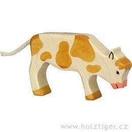 Hnědé strakaté telátko na pastvě - dřevěné zvířátko