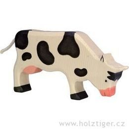 Strakatá černá kravička na pastvě - dřevěné zvířátko