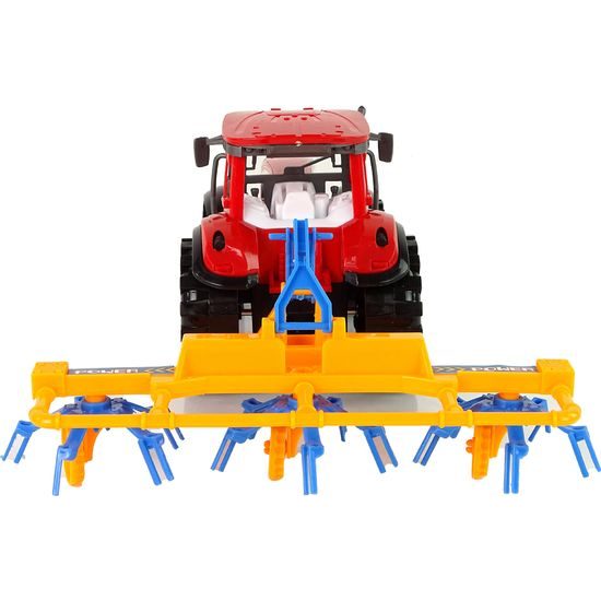 Červený traktor s obracečkou na setrvačník